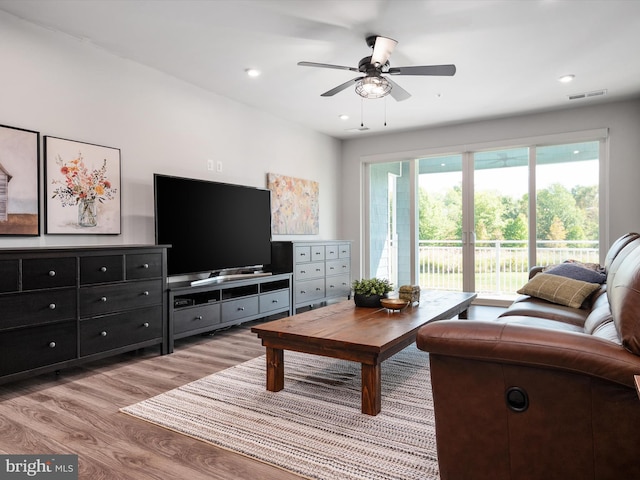 living room featuring ceiling fan and light hardwood / wood-style floors