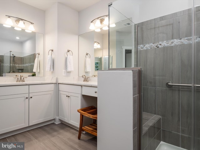 bathroom with vanity, hardwood / wood-style floors, and tiled shower