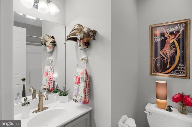 bathroom with vanity, a shower, and toilet