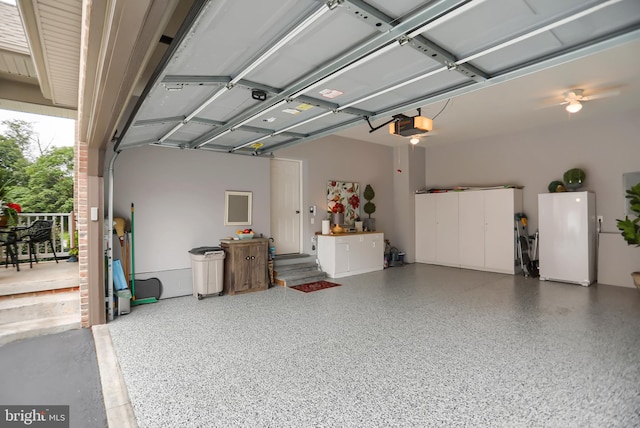 garage with a garage door opener and white fridge