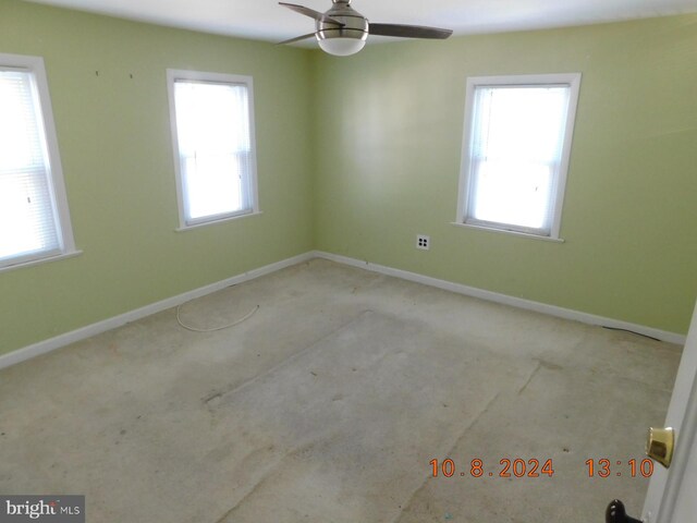 empty room with ceiling fan and a wealth of natural light