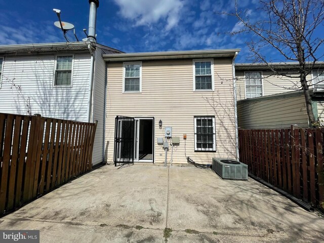 rear view of house with central AC unit and a patio area