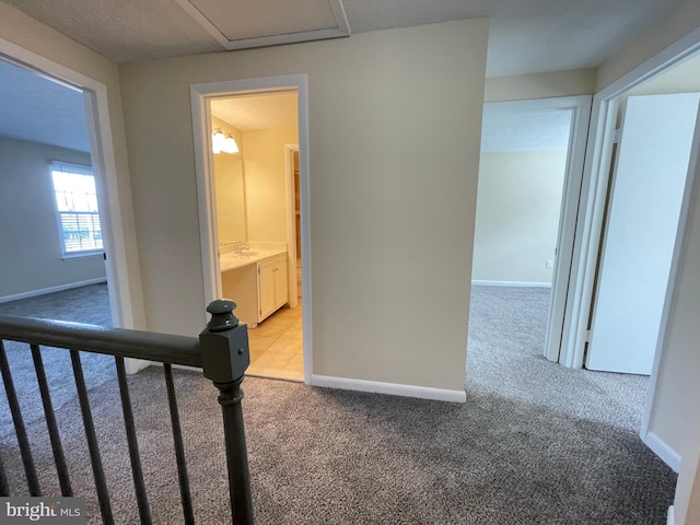 hallway featuring light colored carpet