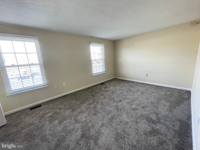 carpeted spare room with a textured ceiling