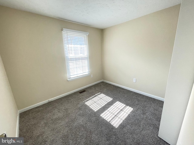 carpeted spare room featuring a textured ceiling