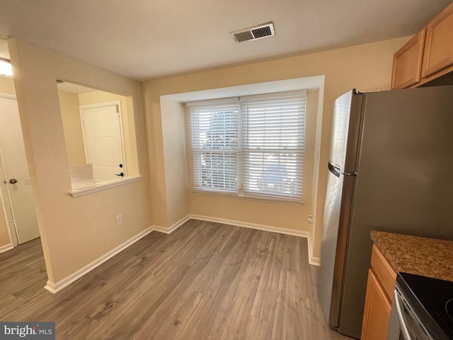 kitchen featuring hardwood / wood-style flooring and stainless steel fridge