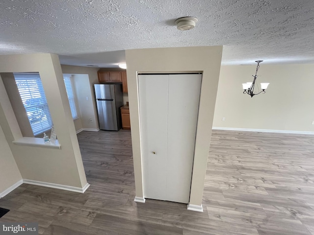 interior space with a textured ceiling, a chandelier, and hardwood / wood-style floors