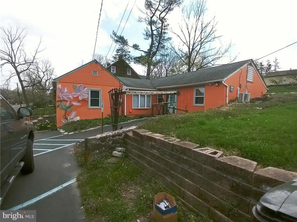 back of property with cooling unit and a yard