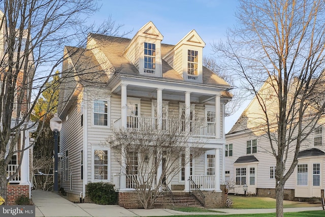 view of front of property featuring a porch and a balcony