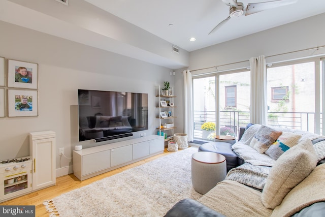 living room featuring plenty of natural light, light wood-type flooring, and ceiling fan