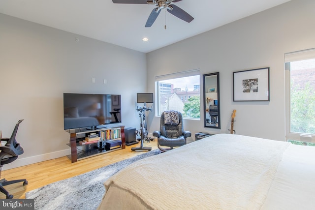 bedroom featuring wood-type flooring, multiple windows, and ceiling fan