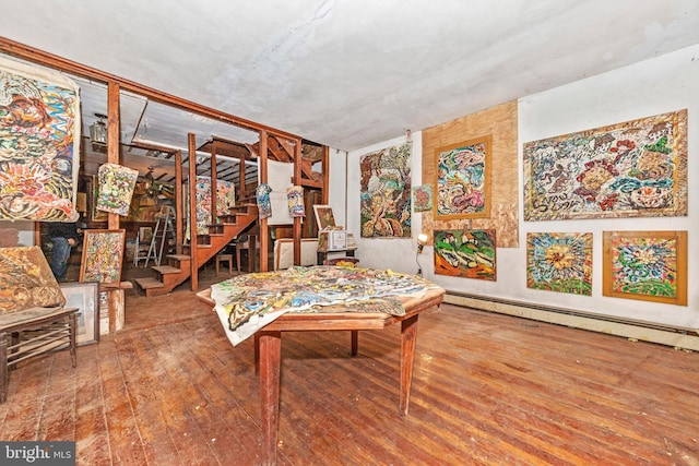 game room with baseboard heating and wood-type flooring