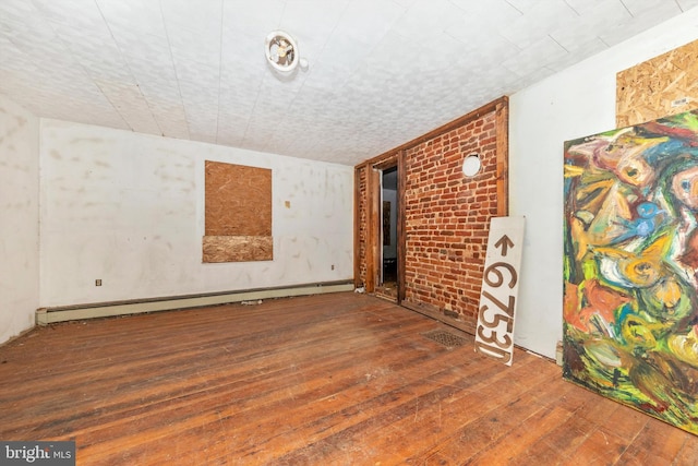 spare room featuring dark hardwood / wood-style flooring and baseboard heating