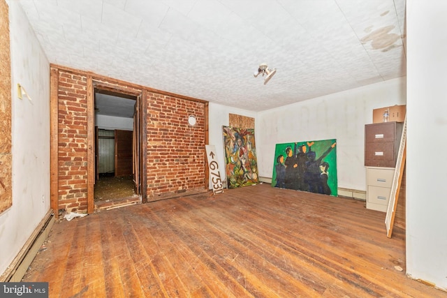 unfurnished room featuring hardwood / wood-style floors and baseboard heating