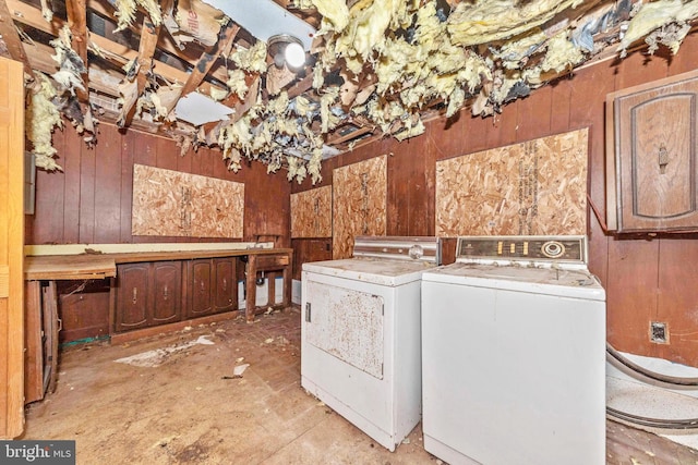 laundry area featuring wood walls and washer and dryer