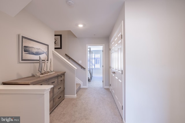 hallway featuring light colored carpet