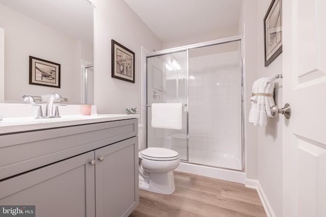 bathroom with vanity, an enclosed shower, hardwood / wood-style floors, and toilet