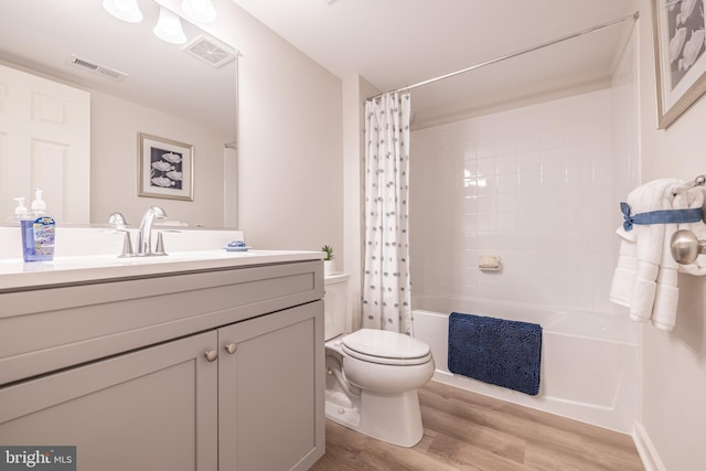 full bathroom with vanity, hardwood / wood-style floors, shower / tub combo, and toilet