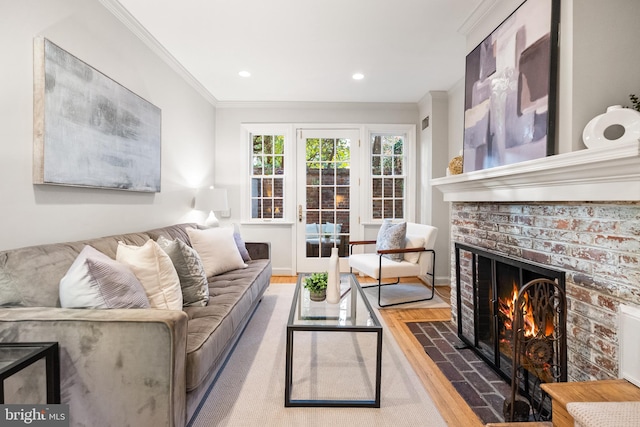 living room with hardwood / wood-style floors, crown molding, and a fireplace