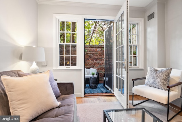 interior space featuring crown molding and light hardwood / wood-style flooring