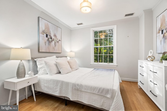 bedroom featuring crown molding and light wood-type flooring