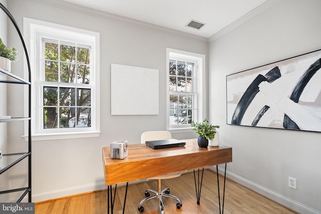 office area featuring light hardwood / wood-style floors, crown molding, and a wealth of natural light