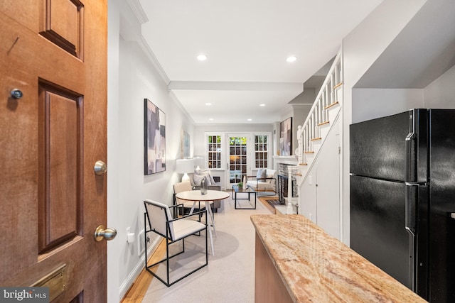 kitchen with french doors, light hardwood / wood-style flooring, black fridge, and crown molding