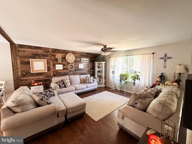 living room with wood walls, dark hardwood / wood-style flooring, and ceiling fan