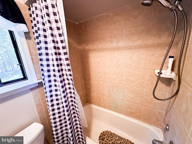 bathroom with toilet and shower / tub combo with curtain