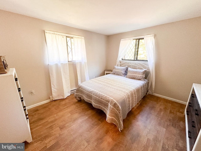 bedroom featuring hardwood / wood-style flooring and a baseboard radiator