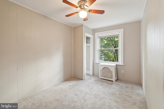 carpeted spare room with ornamental molding and ceiling fan