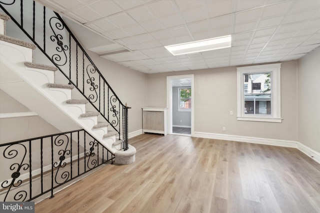 entryway with a paneled ceiling and light hardwood / wood-style floors