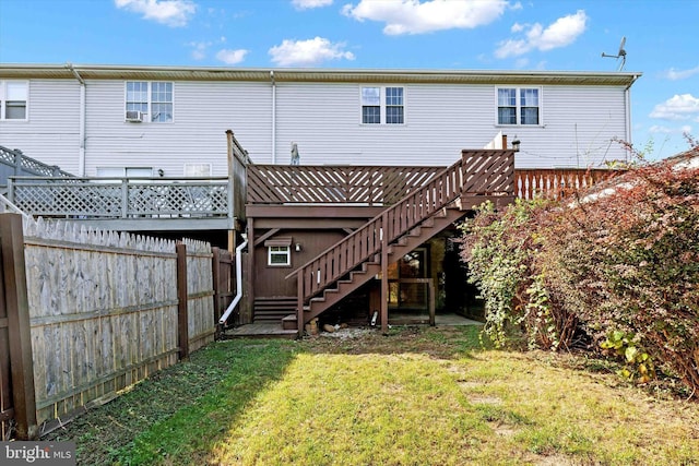 back of property with a deck and a yard