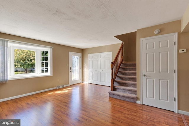 entryway featuring hardwood / wood-style flooring and a textured ceiling