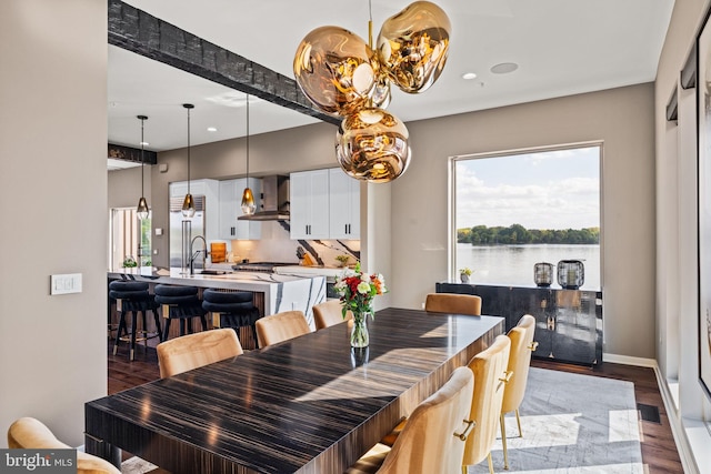 dining area with a water view, sink, and dark hardwood / wood-style flooring