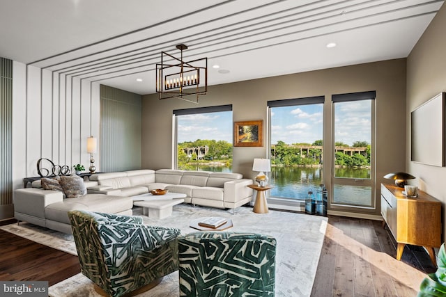 living room with wood-type flooring, a chandelier, and a water view