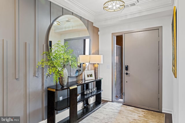 foyer with crown molding and hardwood / wood-style floors