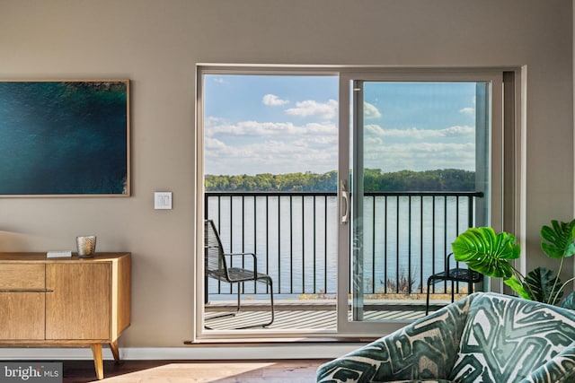 interior space featuring a water view, multiple windows, and hardwood / wood-style floors