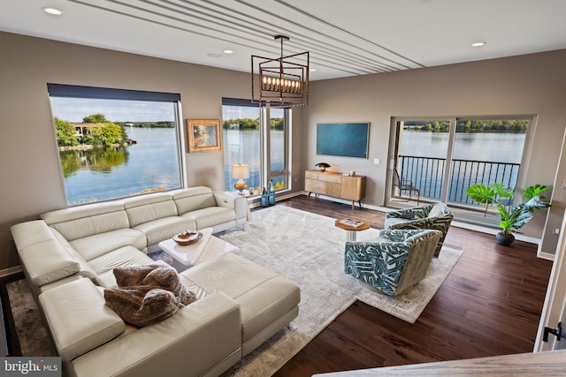 living room featuring a water view, plenty of natural light, and dark wood-type flooring