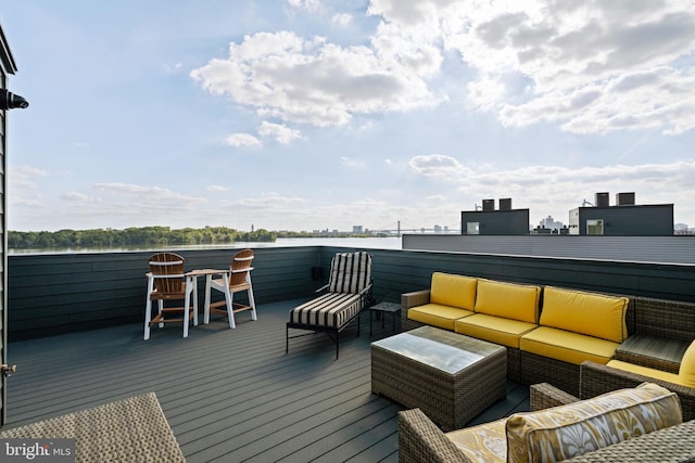 wooden deck with an outdoor hangout area and a water view