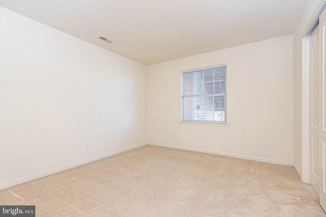 spare room featuring light carpet