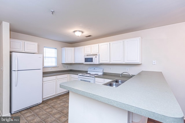 kitchen with white appliances, sink, kitchen peninsula, and white cabinets