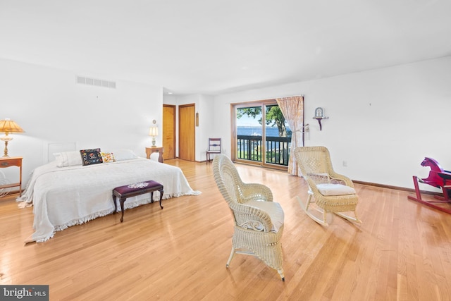 bedroom with light wood-type flooring and access to exterior