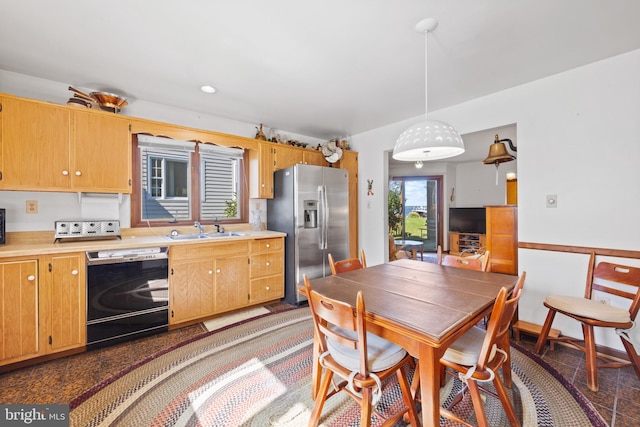 kitchen featuring sink, black dishwasher, stainless steel fridge with ice dispenser, and pendant lighting