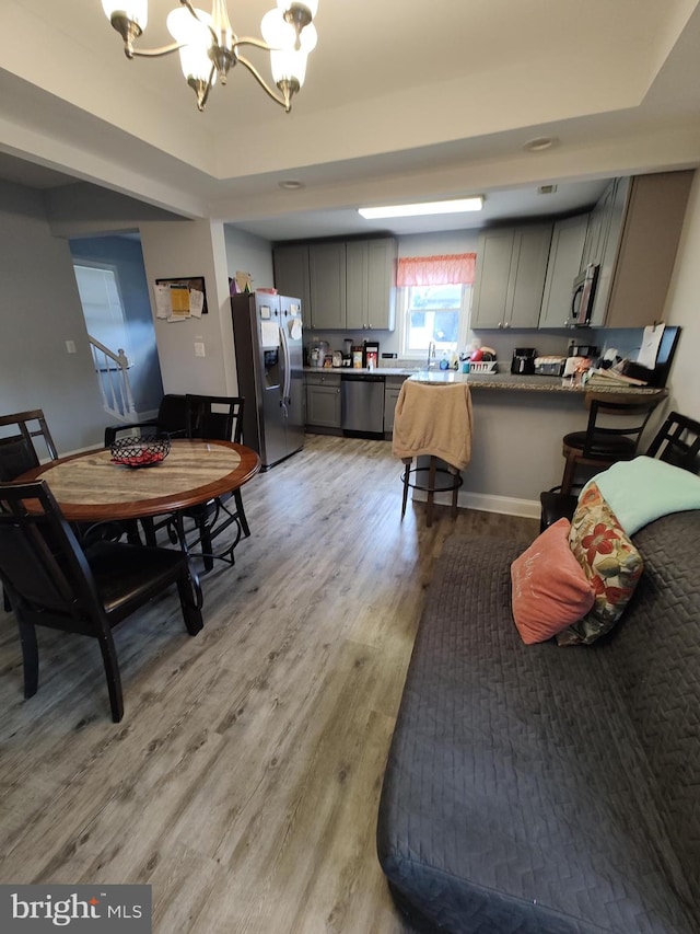 dining room featuring light hardwood / wood-style floors, sink, and an inviting chandelier