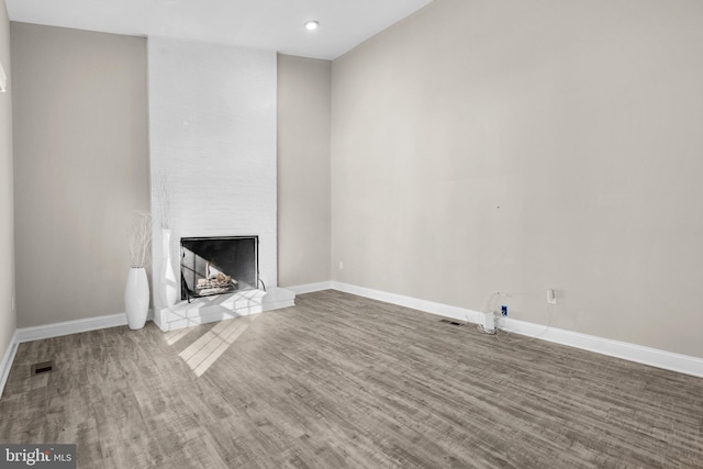 unfurnished living room with a fireplace and wood-type flooring