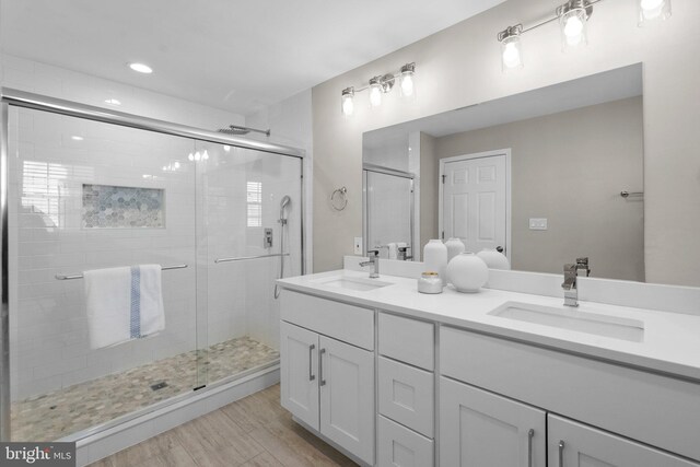 bathroom featuring walk in shower, vanity, and wood-type flooring