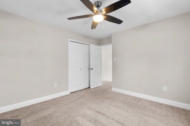 unfurnished bedroom featuring a closet, carpet floors, and ceiling fan