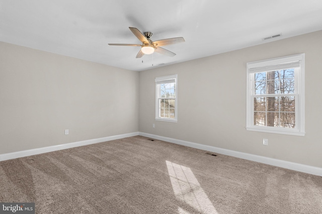 carpeted empty room featuring a healthy amount of sunlight and ceiling fan