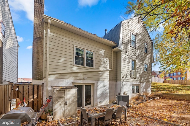 back of house with central AC unit